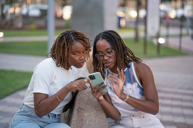 Two Women Sharing Phone Together