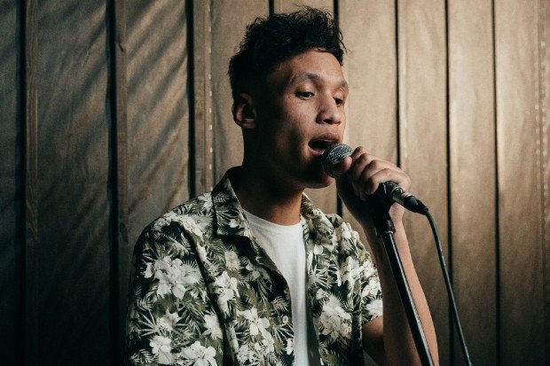 Young Man Speaking Into Microphone